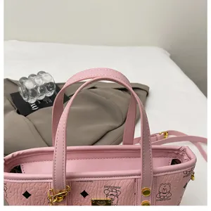 Pink bucket bag detailed view, cute bear print design with top handles and shoulder strap.