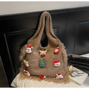 Close-up detail of brown knit tote bag with Christmas plush patches and fringe accents.