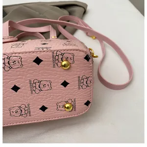 Pink bucket bag detail featuring cute bear monogram print, compact crossbody handbag.