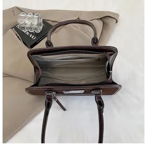 Detailansicht der dunkelbraunen Vintage-Umhängetasche mit geräumigem Innenfach und Reißverschluss.