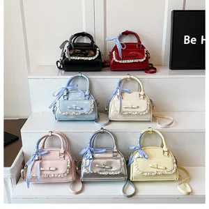 Women small handbag fashion patent leather shoulder crossbody bag with lace bow decoration.