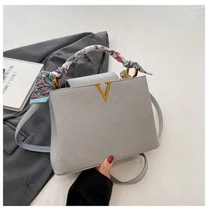 Grey leather top handle bag with metal V logo and stylish printed silk scarf decoration.