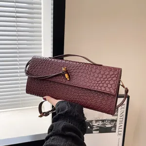 Dunkelroter Schlangenhaut-Optik Baguette-Umhängetasche mit Metall-Knoten-Verschluss.