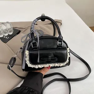 Stylish black women handbag with lace trim, bow and checkered ribbon, versatile crossbody bag.