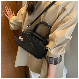 Detailaufnahme der süßen Dackel-Design Bowling-Handtasche in Schwarz für den Alltag.