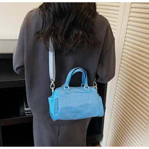 Gedetailleerd overzicht van de blauwe geruite canvas crossbody tas met handvatten.