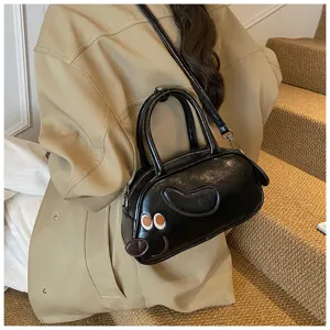 Detailaufnahme der stilvollen schwarzen glänzenden Bowling-Schultertasche mit Hundemotiv.