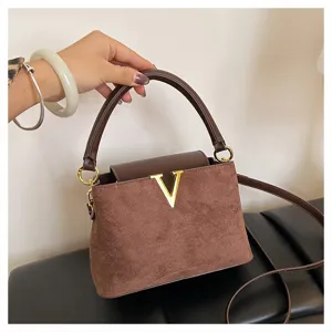 Retro brown suede handbag detail, elegant top handle shoulder bag with gold V accent.