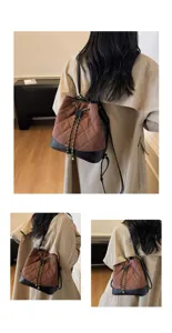 Vista dettagliata della borsa a secchiello trapuntata marrone alla moda con catena.