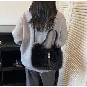 Black fluffy plush shoulder bag detail view, soft faux fur texture with metal lock closure.