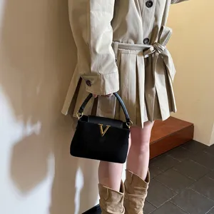 Stylish black crossbody shoulder bag featuring gold V hardware, ideal for autumn use.