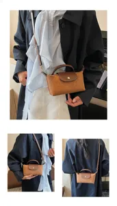 Detalles en primer plano del elegante bolso bandolera de ante marrón con asa.
