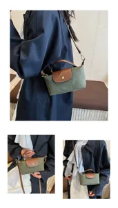 Vista detallada del bolso cruzado de ante elegante con solapa de cuero y asa superior.