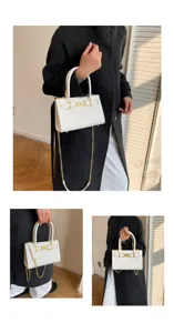 Detail van de witte handtas met krokodillenprint en luxe gouden hardware en kettingriem.