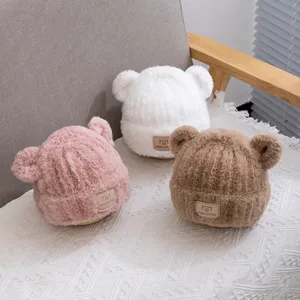 Cute plush bear ear winter hat for kids, warm knitted beanie in pink white and brown colors.