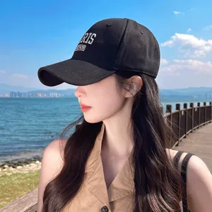 Detailed view of black cotton baseball cap with stylish white embroidery outdoor.