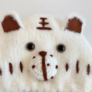 Cute tiger baby knit hat detail close up, soft plush material, warm winter earflap cap.