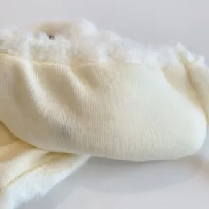 Close up view of infant plush warm earflap hat detail showing soft fleece knit fabric texture.