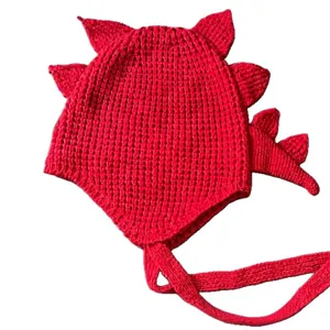 Gorro de dinosaurio de punto rojo con púas dorsales y tiras cálidas de orejas en invierno.