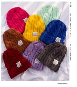 Detailed view of various colorful knitted beanies, chunky cable knit winter warm caps.