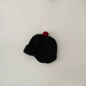 Toddler knitted beanie with cute red pom-pom detail, soft winter warm hat for babies.