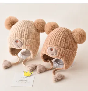Cute baby warm knit hat with double pom poms and adorable bear embroidery.