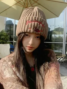 Brown knitted beanie for women featuring cute bear embroidery and warm winter fit.