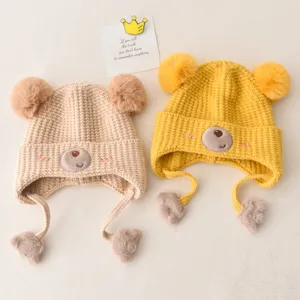 Cute winter baby knit hat with bear ears and earflaps, warm plush pom-pom children beanie.