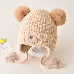 Cute baby winter knit hat with lovely bear embroidery, double pom poms and warm earflaps.