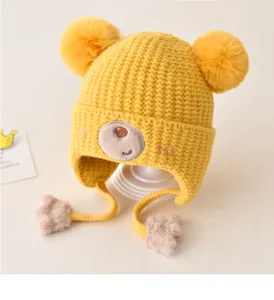 Cute baby winter knit hat with double pom poms, earflaps, and sweet bear embroidery for kids.