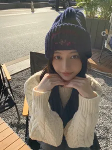 Close-up detail of knitted beanie hat with cute bear embroidery for women winter style outdoor.
