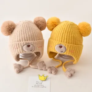 Cute baby winter earflap knitted hat with double pom poms and bear face embroidery main view