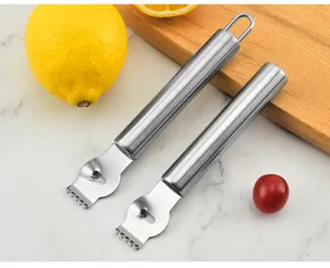 Vue détaillée d'un zesteur de citron en acier inoxydable sur comptoir en marbre.