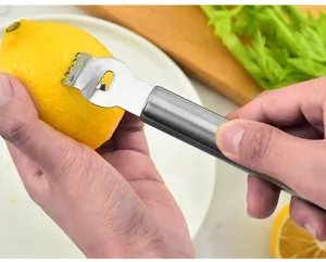 Zesteur de citron en cuisine en acier inoxydable pour peler facilement les agrumes.
