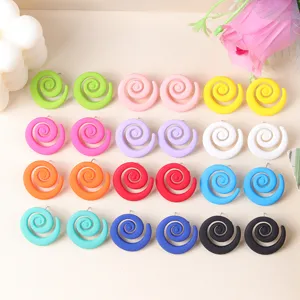 Detail view of colorful spiral candy earrings, geometric acrylic ear studs for women fashion.
