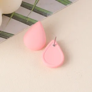 Close-up detail of minimalist pink teardrop acrylic stud earrings with metal pin.