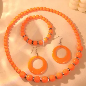 Candy color orange acrylic beaded necklace bracelet and hoop earrings jewelry set detail view.