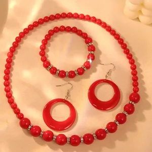Close-up details of red candy bead jewelry set, featuring acrylic rings and retro necklace.