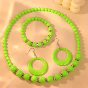 Neon green acrylic bead necklace bracelet and large hoop earrings jewelry detail view.