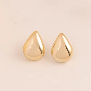 Vue de detail de boucles d'oreilles goutte dorees, accessoire de bijouterie metallique.