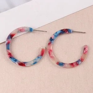 Boucles d'oreilles créoles C en acétate coloré, design en résine marbrée élégante.