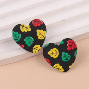 Primer plano detallado de pendientes de acrílico negro con estampado de hojas.