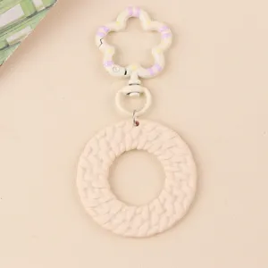 Gros plan détail du porte-clés fleur acrylique couleur bonbon bohème, pendentif circulaire.