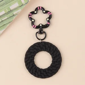 Porte-clés rond noir tressé minimaliste avec fermoir floral mignon, accessoire de sac.