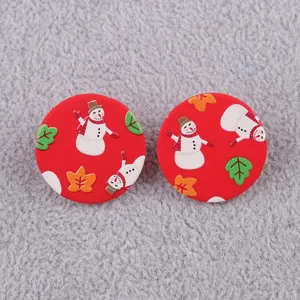Nahaufnahme Detail roter runder Acryl Ohrringe mit niedlichem Weihnachtsschneemann und Blattmuster.