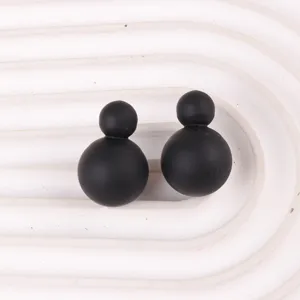 Detailaufnahme von mattschwarzen Doppelball-Ohrringen, minimalistischer Acrylschmuck.