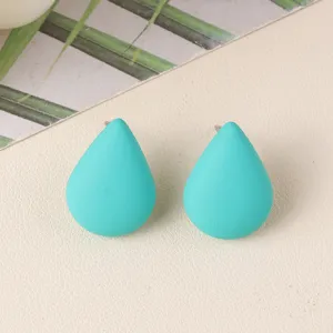 Close-up detail of turquoise teardrop acrylic stud earrings, minimalist chic jewelry.