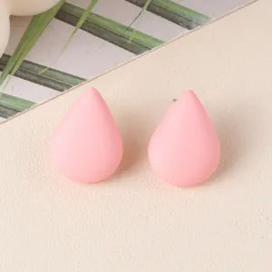 Close-up detail of minimalist pink teardrop acrylic stud earrings, simple elegant design.