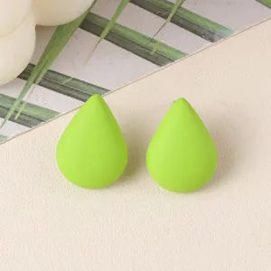 Close-up detail shot of minimalist teardrop green acrylic ear studs, fresh everyday jewelry.