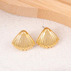 Vue détaillée de boucles d'oreilles puces coquillage dorées, texture nervurée et design élégant.